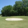 A view of a green protected by a bunker at Upland Trace Golf Club