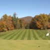 A view of a green with a narrow path on the left side at Boone Golf Club