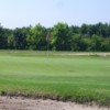 A sunny day view of a green protected by a bunker at Sandy Ridge Country Club