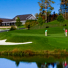 A fall day view of a green with water coming into play and the clubhouse in the distance at Lake Toxaway Country Club